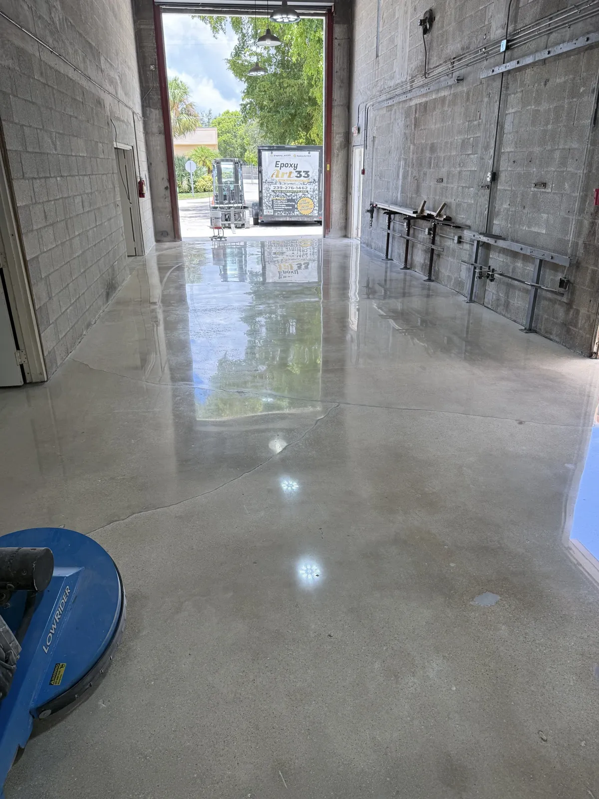 Process — Polishing pass toward the open bay with the planetary grinder on site
